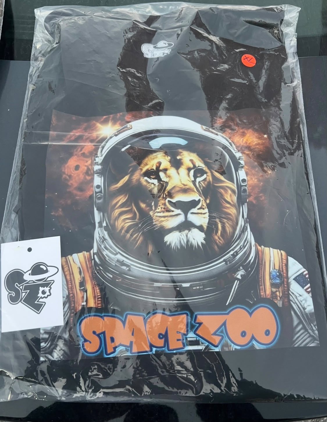 Space Zoo astronaut lion t-shirt packed in a sealed poly bag with size sticker