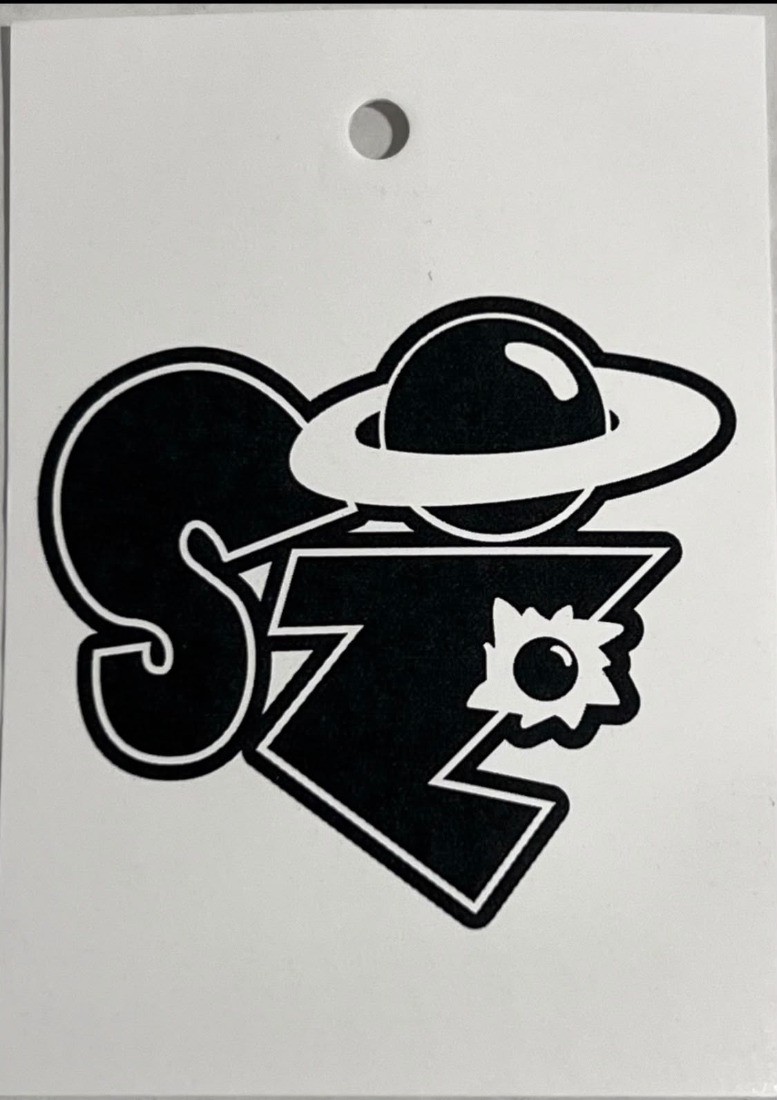 Space Zoo white hang tag with black SZ planet logo